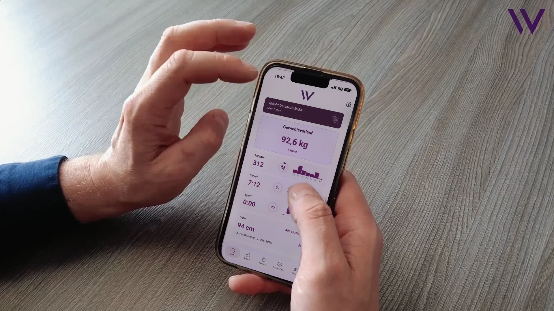 Hand holding a smartphone with the Weight Doctors® App open