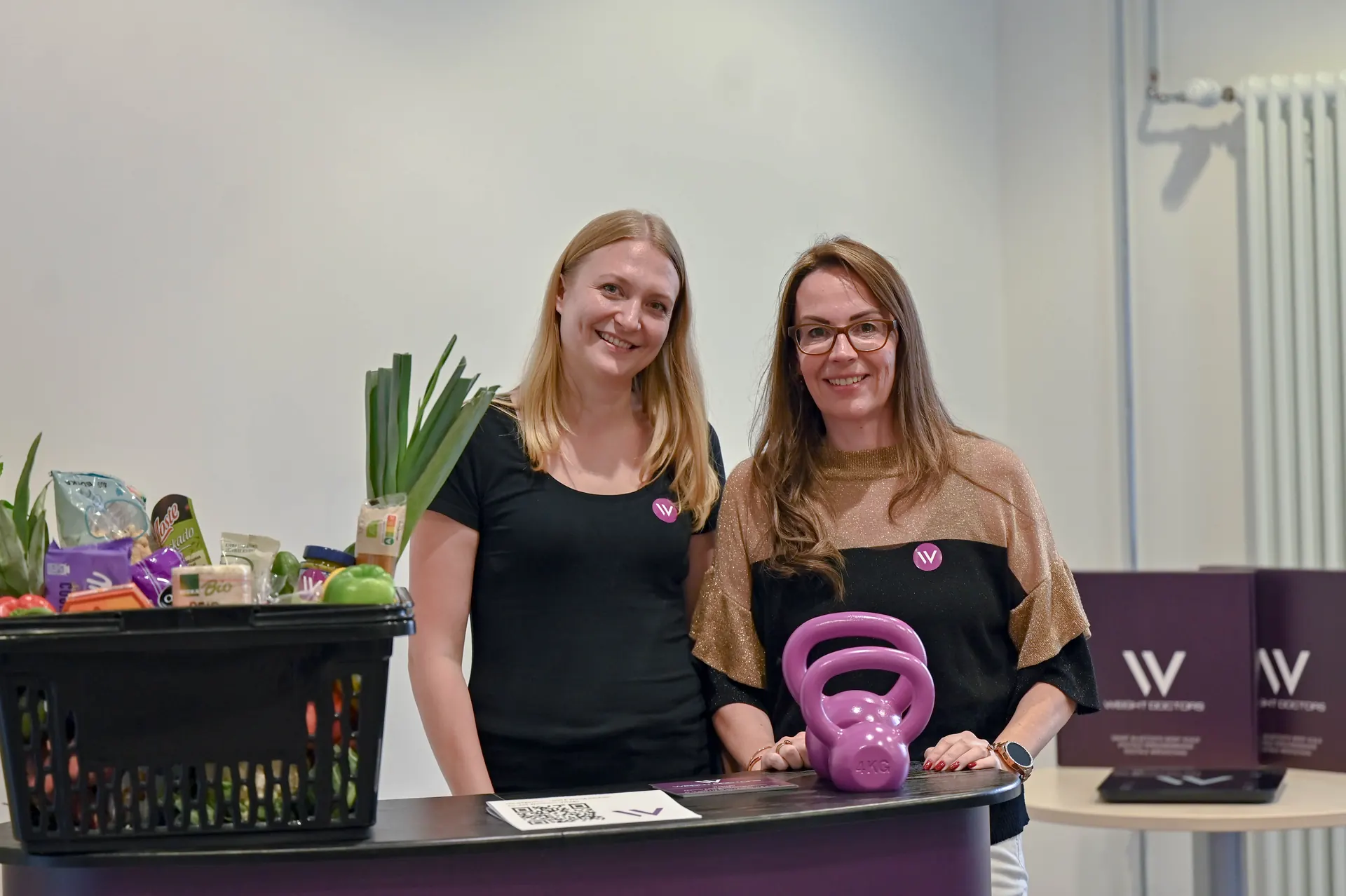 Dau aelod o staff Weight Doctors® gyda ffrwythau a llysiau ffres