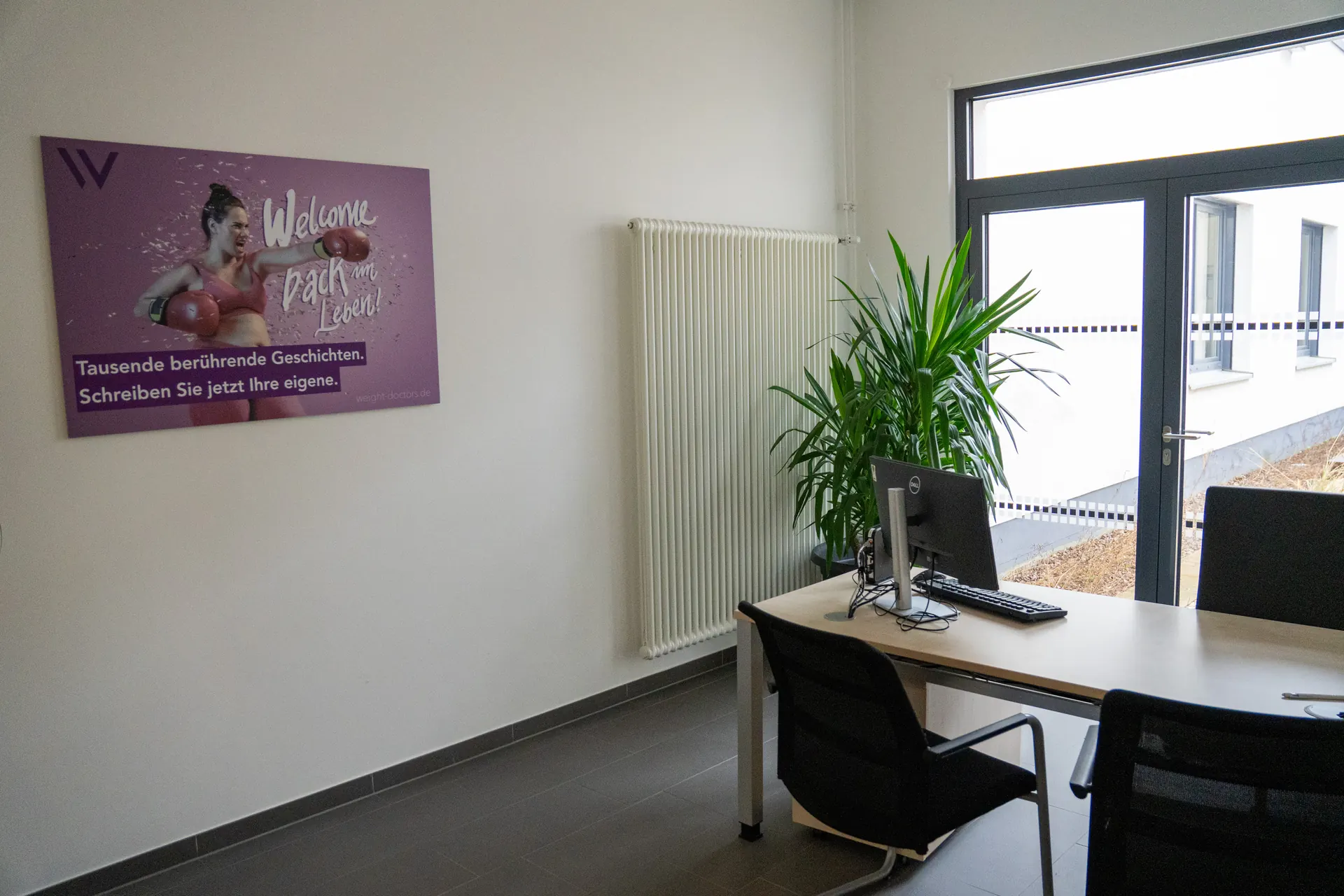 Heller Beratungsraum der Weight Doctors® Nationalklinik mit Schreibtisch und Weight Doctors® Plakat