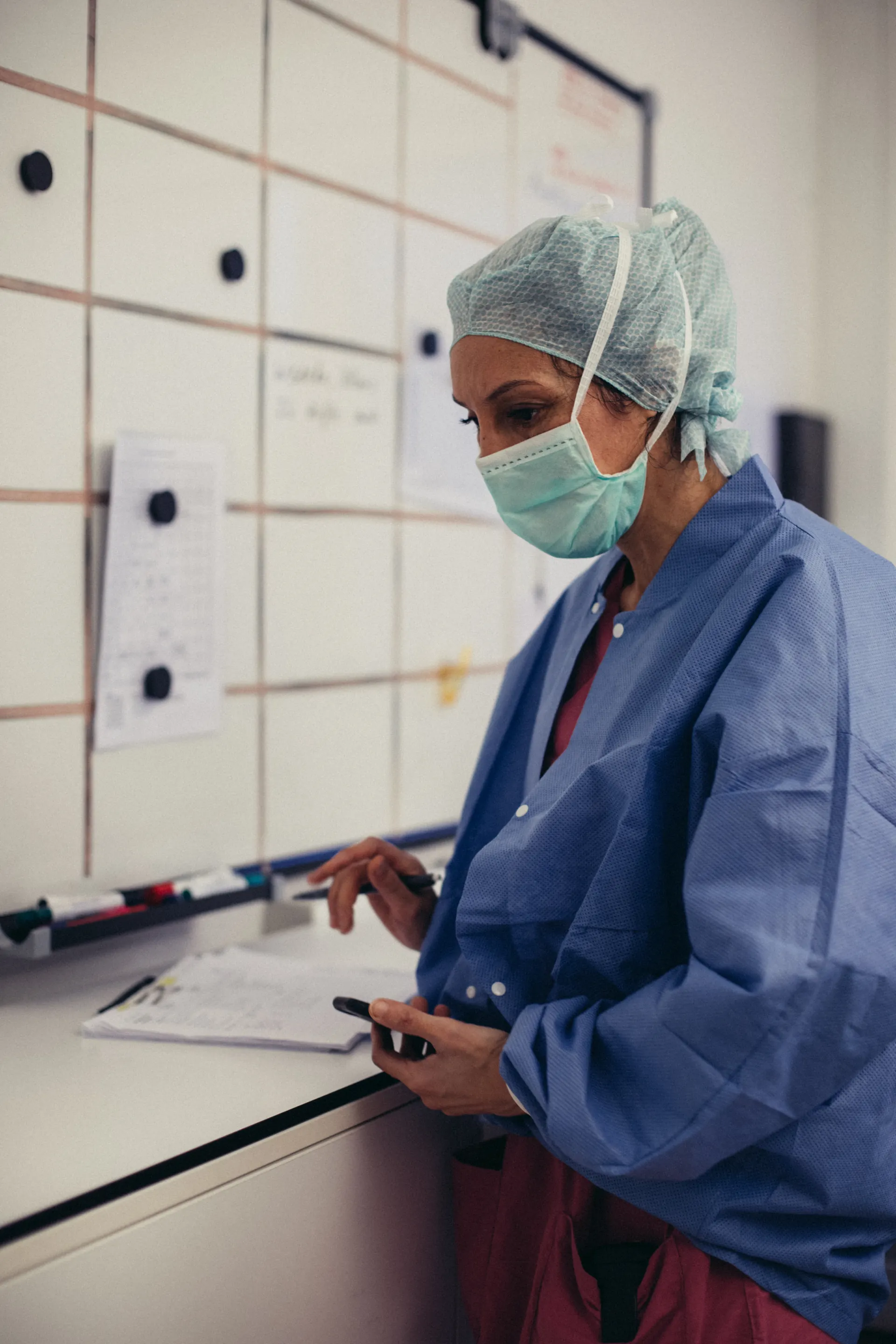 Nurse in a surgical cap planning at a whiteboard
